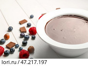 Чаша с вкусным шоколадным фондю и ягодами на столе. Стоковое фото, фотограф Pixel_shot / Фотобанк Лори