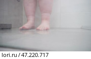 Полные ноги в душе с следами от носков на лодыжках Крупный план мокрых полных ног в душе, стоящих на кафельном полу. На коже заметны следы от носков, оставшиеся на лодыжках. Тёплый пар создаёт мягкую, слегка размытая атмосферу, передающую ощущение уюта и расслабления после долгого дня. Стоковое видео, видеограф Анна Чижова / Фотобанк Лори