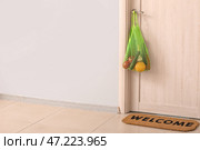 Сумка с продуктами, оставленными курьером службы доставки еды, висит на двери. Понятие эпидемии. Стоковое фото, фотограф Pixel_shot / Фотобанк Лори