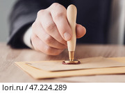 Нотариус с печатью работает в офисе, крупным планом. Стоковое фото, фотограф Pixel_shot / Фотобанк Лори