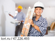 Builder boy carries a ladder. Helping parents to renovate room. Стоковое фото, фотограф Яков Филимонов / Фотобанк Лори
