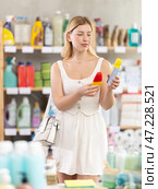 Young woman choosing repellent in supermarket. Стоковое фото, фотограф Яков Филимонов / Фотобанк Лори