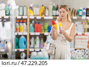 Young girl choosing insect repellent in supermarket. Стоковое фото, фотограф Яков Филимонов / Фотобанк Лори