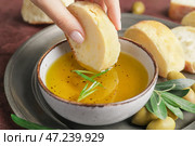 Женщина макает хлеб в миску с вкусными оливками, крупным планом. Стоковое фото, фотограф Pixel_shot / Фотобанк Лори