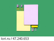 Блокноты со скрепками, точилкой и ластиком на зеленом фоне. Стоковое фото, фотограф Pixel_shot / Фотобанк Лори