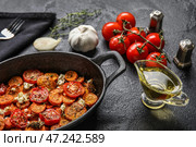 Сковорода с запеченными овощами и соусником с маслом на темном фоне. Стоковое фото, фотограф Pixel_shot / Фотобанк Лори