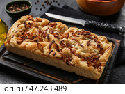 Деревянная доска с вкусной итальянской фокаччей на темном столе, крупным планом. Стоковое фото, фотограф Pixel_shot / Фотобанк Лори