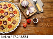 Блюдо для выпечки с вкусной итальянской фокаччей и ингредиентами на деревянном фоне. Стоковое фото, фотограф Pixel_shot / Фотобанк Лори