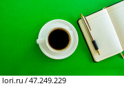 Desktop. Notepad, pen and coffee cup on green background, top view. Стоковое фото, фотограф Юлия Николаева / Фотобанк Лори