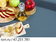 Деревянная доска с соусником из яблочного уксуса и фруктами на цветном столе. Стоковое фото, фотограф Pixel_shot / Фотобанк Лори