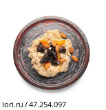 Вкусная овсянка, чернослив, курага и миндальные орехи в тарелке на белом фоне. Стоковое фото, фотограф Pixel_shot / Фотобанк Лори
