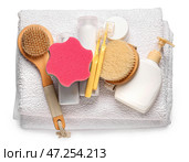 Полотенце, флаконы с косметикой, зубные щетки, мочалка и массажные щетки на белом фоне. Стоковое фото, фотограф Pixel_shot / Фотобанк Лори