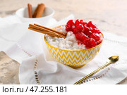 Чаша вкусного рисового пудинга с вишней и корицей на белой салфетке. Стоковое фото, фотограф Pixel_shot / Фотобанк Лори