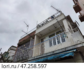 Hong Kong, China - April 06, 2024: Residential building in Hong Kong exhibiting unique architecture and rooftop antennas on a cloudy day. Редакционное фото, фотограф Кривошеина Елена Леонидовна / Фотобанк Лори