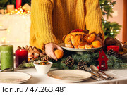 Женщина, подающая вкусные блюда за рождественским столом. Стоковое фото, фотограф Pixel_shot / Фотобанк Лори