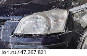 A close-up of a car headlight during a car wash. Стоковое видео, видеограф Mikhail Davidovich / Фотобанк Лори