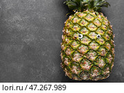 Забавный ананас с глазками на темном фоне. Стоковое фото, фотограф Pixel_shot / Фотобанк Лори