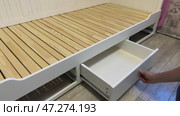 The man installs a linen drawer into the sofa bed. Self-assembly of furniture. Стоковое видео, видеограф Vadzim Yakubovich / Фотобанк Лори