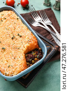 Блюдо для выпечки с вкусным пастушьим пирогом на зеленом фоне, крупным планом. Стоковое фото, фотограф Pixel_shot / Фотобанк Лори