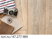 Фотокамера с компасом, блокноты и одежда на деревянном фоне. Стоковое фото, фотограф Pixel_shot / Фотобанк Лори