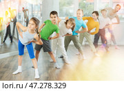 Happy smiling preteen dancers practicing dance routine with female choreographer in studio. Стоковое фото, фотограф Яков Филимонов / Фотобанк Лори
