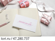 Открытка с текстом DANKe AN ALLE, блокнот, ручка и подарочные коробки на светлом фоне, крупным планом. Стоковое фото, фотограф Pixel_shot / Фотобанк Лори