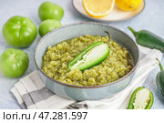 Чаша вкусного зеленого соуса сальса со свежим перцем халапеньо на светлом столе, крупным планом. Стоковое фото, фотограф Pixel_shot / Фотобанк Лори