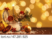 Баночка с рождественским бенгальским огнем, еловые ветки и декор на столе на фоне размытого света. Стоковое фото, фотограф Pixel_shot / Фотобанк Лори