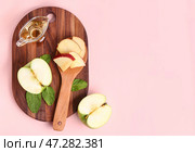 Деревянная доска с соусником из яблочного уксуса и фруктами на розовом фоне. Стоковое фото, фотограф Pixel_shot / Фотобанк Лори