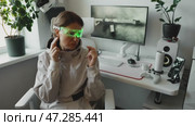 Cyber AI specialist using machine learning algorithms to detect hacking attempts. Bright neon glasses highlights connection between artificial intelligence, cybersecurity, and digital innovation. Стоковое видео, видеограф Енваев Андрей / Фотобанк Лори