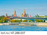 "Парящий мост" парка "Зарядье" на фоне Спасской башни Московского Кремля и Храма Василия Блаженного. Солнечный осенний день. Москва. Редакционное фото, фотограф E. O. / Фотобанк Лори