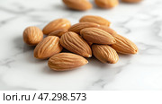 Nuts are arranged on a marble surface showcasing detailed textures in natural light. Орехи разложены на мраморной поверхности, демонстрирующей детальные текстуры при естественном освещении. Стоковое AI-изображение, AI-художник Katsiaryna Repich / Фотобанк Лори
