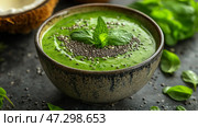 Healthy green smoothie bowl topped with seeds and fresh mint in a rustic setting. Миска здорового зеленого смузи с семенами и свежей мятой в деревенской обстановке. Стоковое AI-изображение, AI-художник Katsiaryna Repich / Фотобанк Лори