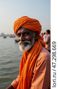 In the heart of Varanasi, an elderly man adorned in a bright orange turban gazes thoughtfully towards the Ganges River, embodying the calmness of ancient traditions and wisdom Generative AI. Стоковое AI-изображение, AI-художник Юлия Петровская / Фотобанк Лори