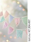 Decorative fabric bunting with pastel colors and sequins creating a festive atmosphere at a celebration or event. Стоковое AI-изображение, AI-художник Сергей Толмачёв / Фотобанк Лори