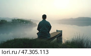 Quiet reflection by the serene lake at dawn with mist and mountains in view. Стоковое AI-видео, аниматор Александр Довянский / Фотобанк Лори