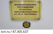 Вывеска для слабовидящих людей с объемными буквами и текстом написанным шрифтом Брайля. Надпись Дворец культуры имени Ю.А. Гагарина и кнопка вызова помощи. Россия, Сергиев Посад, 12 февраля 2025. Редакционное фото, фотограф Ирина / Фотобанк Лори