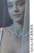 Slow motion vertical video of young female covered with veil. Woman is dressed in a peignoir and wears a necklace and earrings. Стоковое видео, видеограф Сергей Пристяжнюк (Serg Zastavkin) / Фотобанк Лори