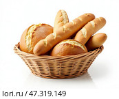 A variety of freshly baked bread rolls and sticks are neatly arranged in a woven basket, showcasing their golden crusts against a clean white background. Стоковое AI-изображение, AI-художник Sergey Grishin / Фотобанк Лори