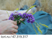 Венок из полевых цветов в руках девушки - традиционный обряд на Ивана Купалу. Стоковое фото, фотограф Snezka / Фотобанк Лори
