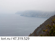 Вид на морской залив и побережье. Низкая облачность. Пасмурная погода. Осенний сезон. Побережье Охотского моря, Магаданская область, Дальний Восток России. Размытый передний план. Стоковое фото, фотограф Андрей Степанов / Фотобанк Лори