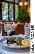 Delicious Greek dolmades served with fresh lemon and tzatziki in a Mediterranean dining setting. Стоковое AI-изображение, AI-художник 123 12 / Фотобанк Лори