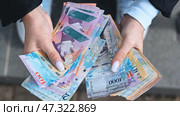 Woman displaying fanned venezuelan bolivar banknotes, highlighting financial exchange. Стоковое фото, фотограф Mikhail Davidovich / Фотобанк Лори