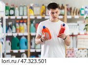 Young man choosing unclogging gel in store. Стоковое фото, фотограф Яков Филимонов / Фотобанк Лори