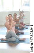 Female coach slowly performs variations of cows head asana, breathing practice and meditation. Стоковое видео, видеограф Яков Филимонов / Фотобанк Лори