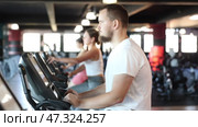 Man performs exercises with stationary bicycle in gym. Стоковое видео, видеограф Яков Филимонов / Фотобанк Лори