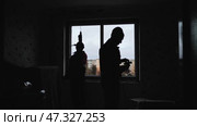 Silhouettes of builders drill the walls to install windows. Стоковое видео, видеограф Mikhail Davidovich / Фотобанк Лори
