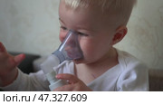 The kid breathes funny and plays with a medical inhaler. Стоковое видео, видеограф Mikhail Davidovich / Фотобанк Лори