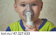 The kid breathes in a mask with an inhaler. Стоковое видео, видеограф Mikhail Davidovich / Фотобанк Лори