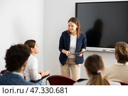 Knowledgeable female professor explaining subject to classroom full of students. Стоковое фото, фотограф Яков Филимонов / Фотобанк Лори